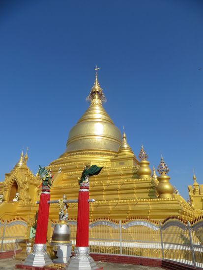 Die goldene Kuppel der Pagode glänzt in der Morgensonne.
