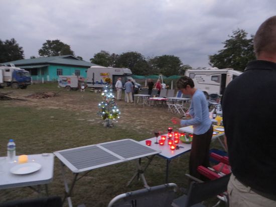 Dann stehen wir in Kalay auf dem Sportplatz rund um das Spielfeld verteilt, denn als wir ankommen ist noch ein Spiel im Gange. 
Als es beendet ist, können wir unsere Tische für unsere Weihnachtsfeier aufbauen, wir schmücken sie weihnachtlich mit Kerzen und ein Plastikweihnachtsbaum versetzt und in feierliche Stimmung .