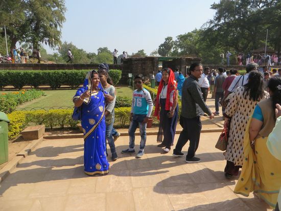 Viele bunt gekleidete Menschen besichtigen den Tempel. Wir müssen dann mit ihnen für ein Foto posieren, dann freuen sie sich.