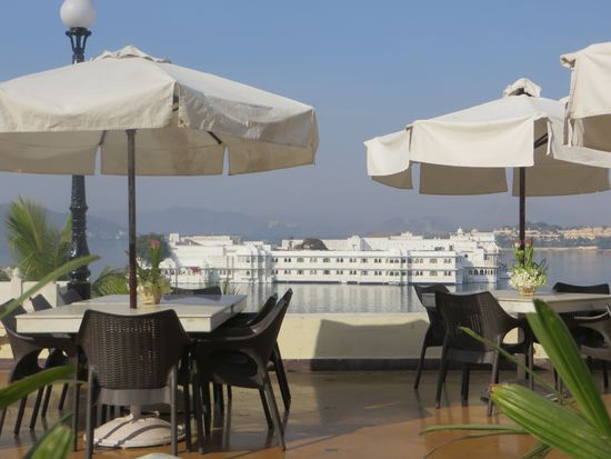 Unter den Sonnenschirmen hindurch ein Blick auf das Lake Palace Hotel, in dem schon einige Filme, wie Oktopussy- James Bond – gedreht wurden.