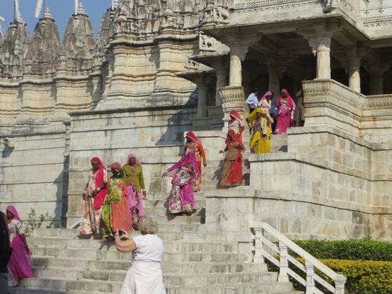 Bunt gekleidete Gläubige kommen aus dem Tempel