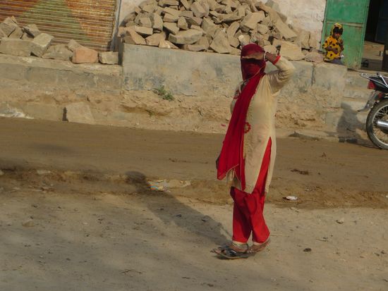 Die Frauen, die auf der Straße herumlaufen verdecken ihr Gesicht mit einem durchsichtigen Schleier