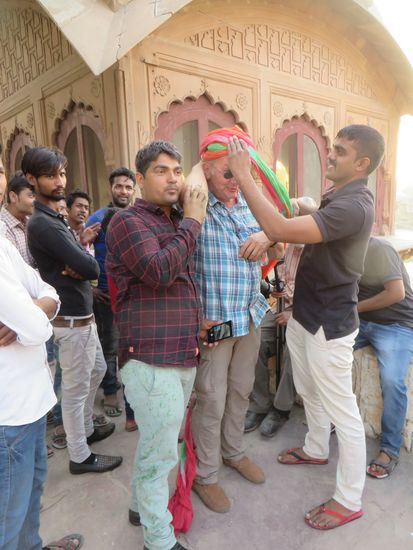 Christian bekommt einen Turban gebunden, den er mit nach Hause nehmen darf