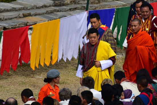 der schreitet zum Thangka hin, vorbei an seinen Untertanen