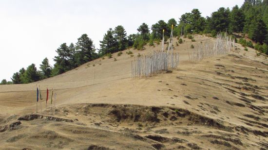 Die weißen Fahnen erinnern an einen Verstorbenen, sie werden beim Tod aufgestellt und sollen ein halbes Jahr stehen bleiben, meist sind sie aber länger dort bis sie verwittert sind.