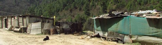 In diesen Blechhütten leben die Bauarbeiter, direkt neben der Straße.