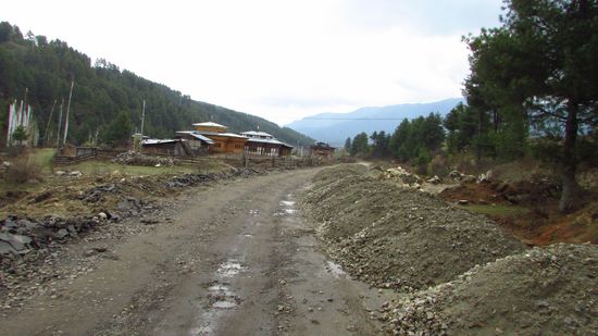 Auch in den Dörfern reiht sich Loch an Loch. Am Straßenrand liegt schon der Schotter zur Reparatur der Straße.