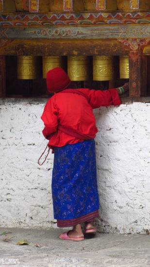 Die Gebetsmühlen werden von einer alten Frau bei ihrer Umrundung des Klosters immer wieder gedreht.