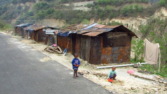 Wir kommen wieder an den Wellblechhütten der Straßenarbeiter vorbei. Die Straße ist kurz geteert, dann geht der Kampf wieder los.