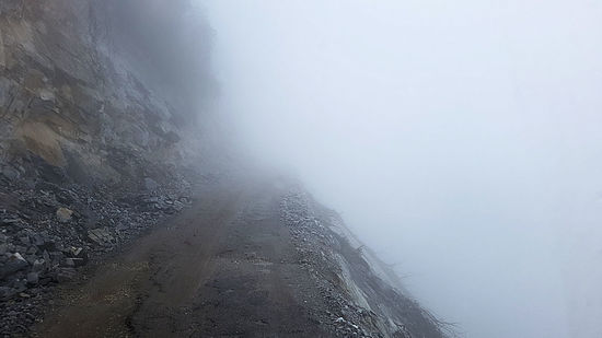 Nebel liegt in den Bergen und auch auf der Straße, aber wir müssen durch.