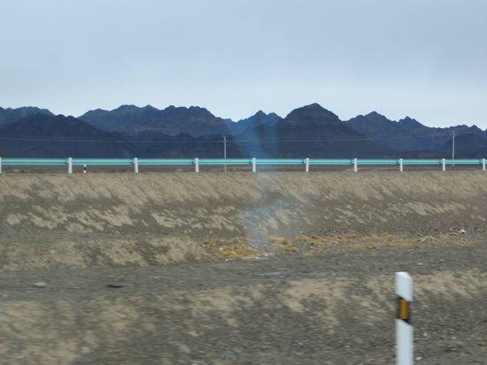 Langsam tauchen aus dem Dunst die Berge auf, und wir fahren an einem Gebirgszug vorbei