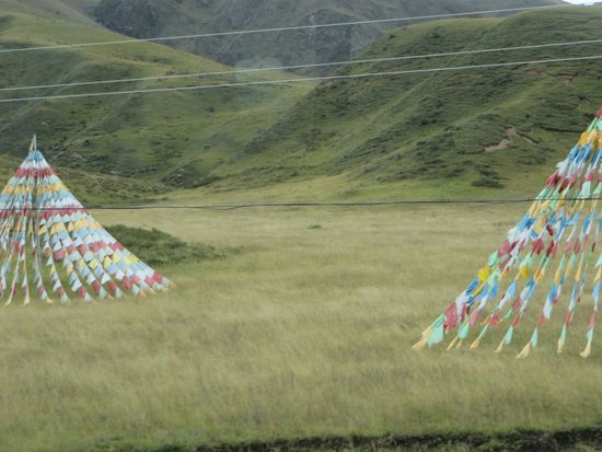 Dann ging die Fahrt weiter, es ging bergauf und bergab, das Wetter war heute schön, die Sonne schien. 
Immer wieder waren bunte Fahnen, Gebetsfahnen? Wie Zelte aufgestellt.