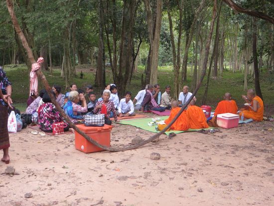 Mönche besuchen auch die Reste  der ehemaligen Tempel hier im Wald. 
Sie  sitzen hier bei einem Picknick direkt vor den Ruinen.