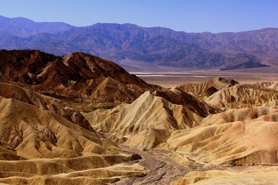 Blick vom Zabriskie Point, welcher für seine bizarren Erosionslandschaften bekannt ist. Die Gesteinsformationen sind versteinerte Sedimente (bestehend aus Salzkrusten, Geröll von den nahen Bergen und Asche des damals aktiven Black Mountain Vulkanfelds) des ehemaligen Furnace Creek Lake, der vor fünf Millionen Jahren ausgetrocknet ist. 
Die Landschaft wirkt irgendwie irreal und somit äußerst beeindruckend!