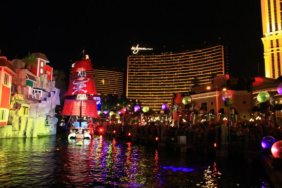 Hier vor dem Treasure Hotel findet abends gratis eine Show statt. 
Im Hintergrund ist das Wynn Hotel zu sehen, welches 2005 mit Baukosten von rund 2,7 Milliarden US-Dollar errichtet wurde. 
Buchbar sind Einheiten mit 58 m2 bis Suiten von 650 m2!