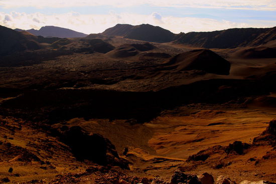 In diesem Verwitterungsbecken erheben sich etwa ein Dutzend kleinere und jüngere Vulkankegel aus grau-schwarz bis gelb-rotem Lavagestein