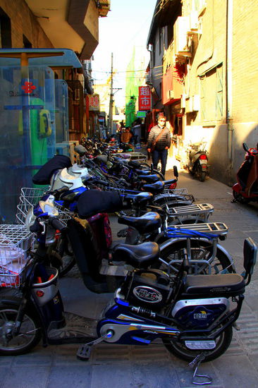 In Peking fahren alle ELEKTROrollers! 
Aus einem Zeitungsartikel von 2009: 
"Mehr als 60 Millionen solcher Gefährte sind schon in China unterwegs, jährlich werden über 20 Millionen Stück produziert. Die chinesischen Stadtregierungen wollten vor allem die Luftqualität verbessern, auch die Ölknappheit spielte eine Rolle. 
Ein massives Problem sind aber ihre Bleiakkus. Nach groben Schätzungen gelangen 30 bis 70 Prozent des giftigen Akkustoffs bei der Produktion und beim Recycling in die Umwelt.  Die erschreckend hohen Verluste entstehen vor allem deshalb, weil ein großer Teil des Bleis in kleinen Fabriken mit veralteter Technik und Bleierzen von sehr schlechter Qualität hergstellt wird.
Über Klima- und Umweltfragen machen sich die chinesischen E-Roller-Piloten wenig Gedanken. Die wendigen Fahrzeuge haben zudem einen großen Vorteil: Viele Pekinger sind täglich drei Stunden zur Arbeit und zurück unterwegs, einen Großteil davon stehen sie im Stau. Da erscheinen die vorbeiziehenden Elektrozweiräder besonders reizvoll. Ihre Batterieladung reicht bis zu 50 Kilometer."