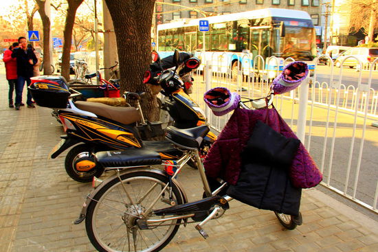 Die Pekinger sind gegen die Kälte auf ihren zahlreichen Elektroroller gut geschützt