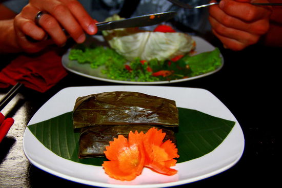 Typisches Dessert: Über dem Feuer werden die von Bananenblätter eingewickelten Bananen von Reis umgeben "grilliert". Mmh, schmeckt gut!
