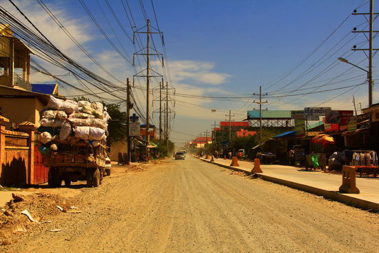 Die Straße etwas abseits des Zentrums. Da kann man sich ja vielleicht vorstellen, wie der Sand &amp; die Steinchen aufgewirbelt werden, wenn Fahrzeuge unterwegs sind. Die Meisten tragen eine Gesichtsschutzmaske à la Chinesen - wir versuchen unsere Riecher in den Shirts zu vergraben....Abends beißen wir auf Sandkörnern rum und im Hals ist`s auch wunderbar spürbar