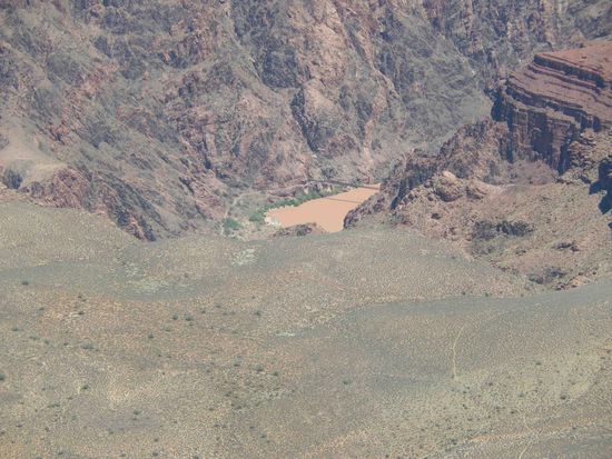 Der braune Fluss in der Mitte ist der Colorado, der sich über viele Meilen durch den Canyon schlängelt.