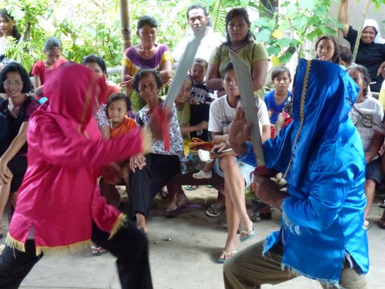 Zwei Frauen "bekriegen" sich beim Tulude Fest auf der Insel Bunaken.