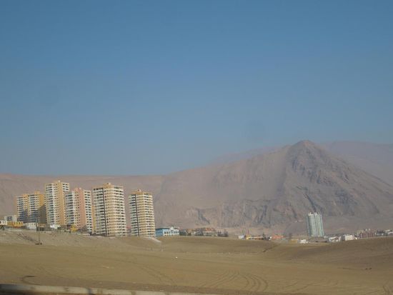 Hochhäuser zwischen Sanddüne und Meer