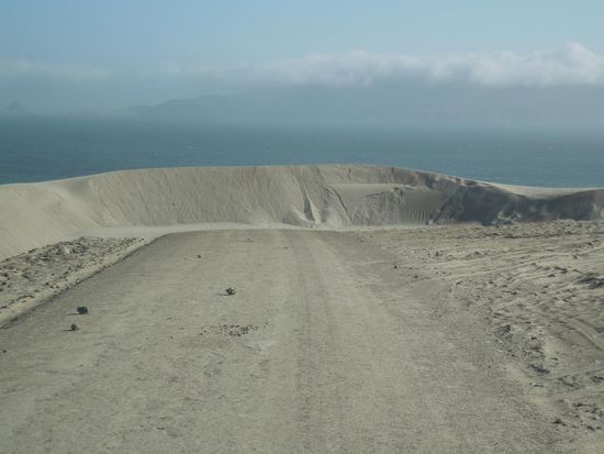 Eine Sanddüne mitten auf der Strasse ... Wüste trifft Pazifik.