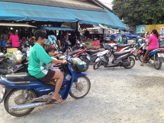 Straßenleben. Man beachte die Helmpflicht, für alle "Insassen" im Land.