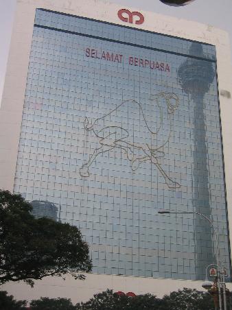 der fernsehturm spiegelt sich im hochhaus neben einem werbe-kamel