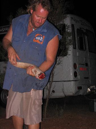 chris (unser guide und fahrer) zeigt den frischen kaenguruhschwanz (den er gleich in der asche des lagerfeuers eingraebt)