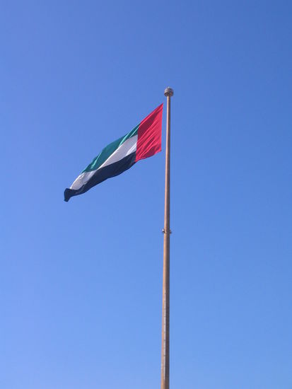 die flagge der vereinigten arabischen emiraten: schwarz steht für das öl, weiß für den frieden, grün für den islam und rot für das blut, das dafür vergossen wurde