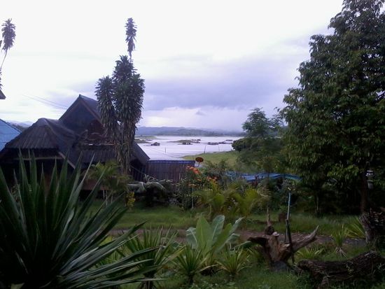 Die Landschaft wird immer grüner und üppinger. Im Hintergrund sind die Hausboote zu sehen, auf denen die Menschen leben, die in Thailand keinen Grundbesitz erwerben dürfen.