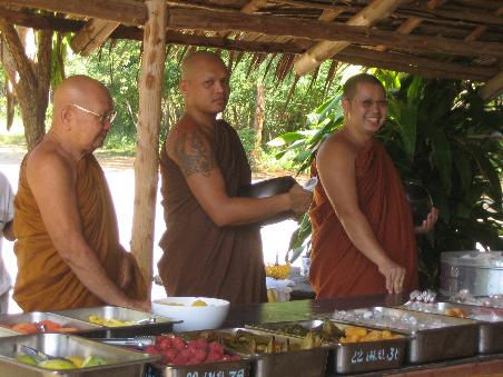 Die Monks (Moenche) holen sich ihre taegliche Mahlzeit vom Buffet, welches aus den Opfergaben der Einheimischen Pak Chongs besteht.