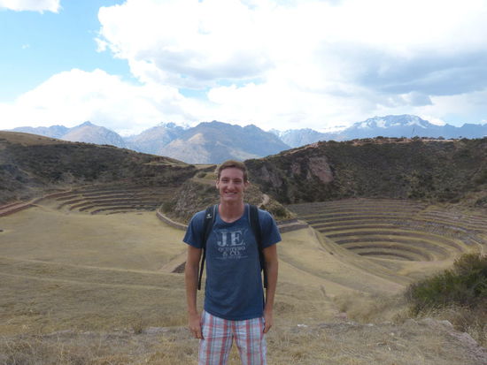 Moray mit Tourist im Vorder- und Bergen im Hintergrund