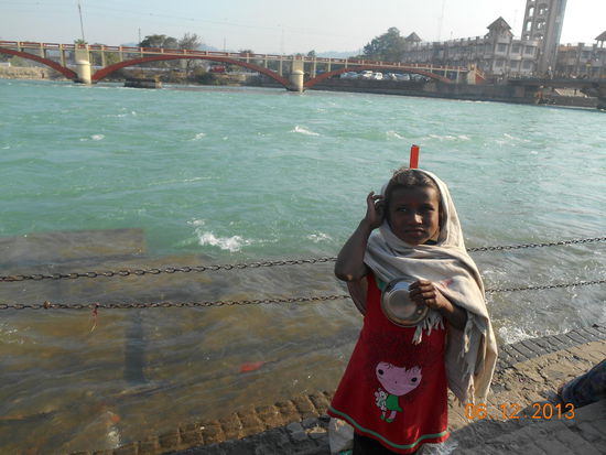 Ein kleines Mädchen bittet mit einer Schüssel um Geld für Essen.