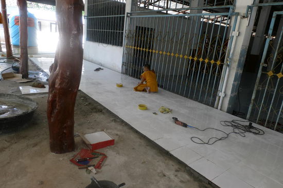 Mönch beim Fliesenlegen