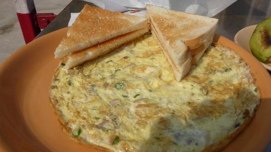 Erst mal Frühstück: Masala-Omlette, Bread, Butter, Banana, und was Süßes (Gulab Jamun) und natürlich Tea