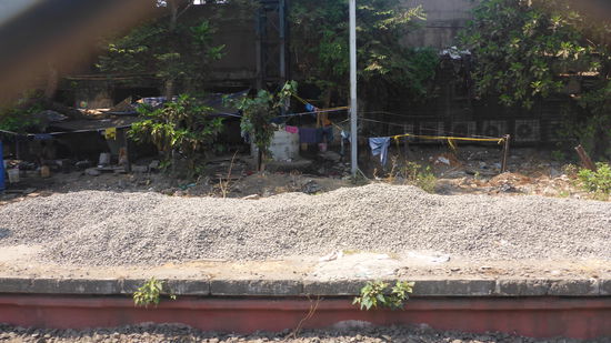 Man kann es leider kaum erkennen, aber da hinten wohnen Menschen, mitten zwischen den Bahngleisen sehr viele Hütten.... auch das gehört zu Mumbai!