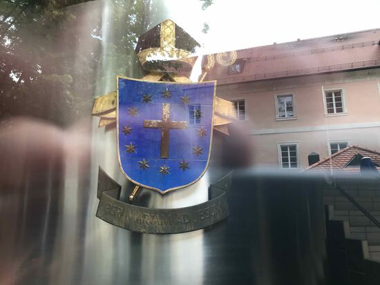 Hinter Glas ein Teil der Brauerei, vor dem Glas das Kloster in der Spiegelung.