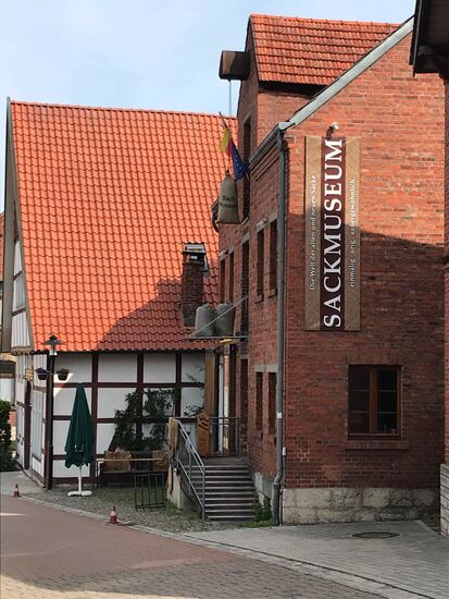 Hier gibt es ein Sackmuseum (O-Ton auf dem Schild: Die Welt der alten und neuen Säcke). Es hängt ein Schild im Fenster "wir haben geöffnet", an der Tür steht "Montags geschlossen". Und es ist wirklich zu.