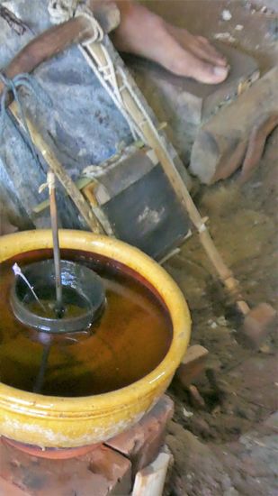 neben den Arbeitern steht eine Schüssel mit Wasser und einer halben Kokosnußschale mit einem Loch. Langsam füllt sich die Schale mit Wasser und nach (ich glaube 3 Min.) ist sie gefüllt, und das Gold dünn genug. Dann wird das nächste Päckchen eingespannt