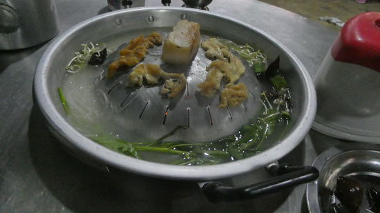 Das Fleisch kommt nach oben. In der Mitte das ist Speck, der langsam zerläuft, und das Fleisch knusprig macht. Das Gemüse kommt in den Sud, köchelt vor sich hin. Der Sud wird anschließend getrunken.
