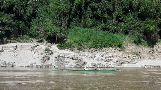 Man sieht ganz gut, wie hoch das Wasser zur Regenzeit steht. Jetzt ist der Wasserstand tief, und der Schiffer muß viele Untiefen und Steine umschiffen.