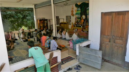 im Dorf findet gerade eine Zeremonie statt, wo Novizen zu Mönchen geweiht werden, ihre orangfarbene Kutte bekommen.