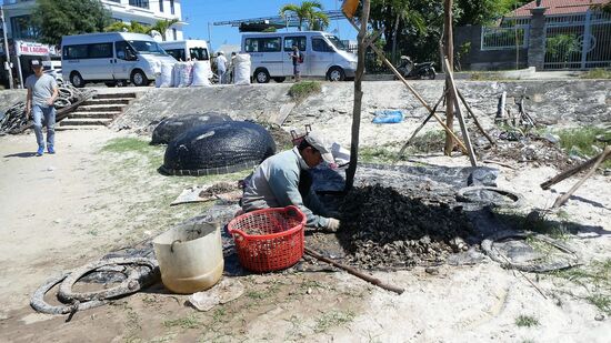 Die runde Wanne im Hintergrund ist ein Boot, gebaut aus Bambus und mit Teer bestrichen, damit es wasserdicht ist.