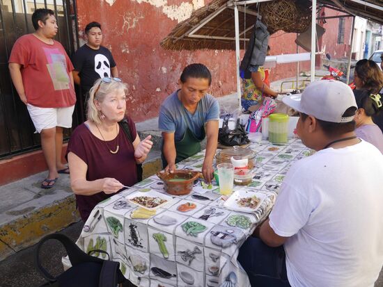 Draußen auf Plastikstühlen oder Hockern. Mexikanisches Essen direkt neben der mobilen Küche. Ein perfektes Frühstück.