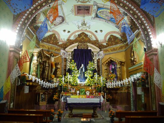 Die kleine Kirche auf dem Friedhof ist schon am Vorabend herausgeputzt. Gerippe und Skelette umsäumen die Jungfrau Maria.