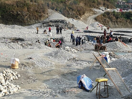 Hier auch an einem heiligen Fluss, im Vordergrund sieht man die Siebe für die normalen Steinbrucharbeiten, die hier ebenfalls neben den Verbrennungen weiterlaufen.Söhnen der/des Verstorbenen die Haare geschoren werden.