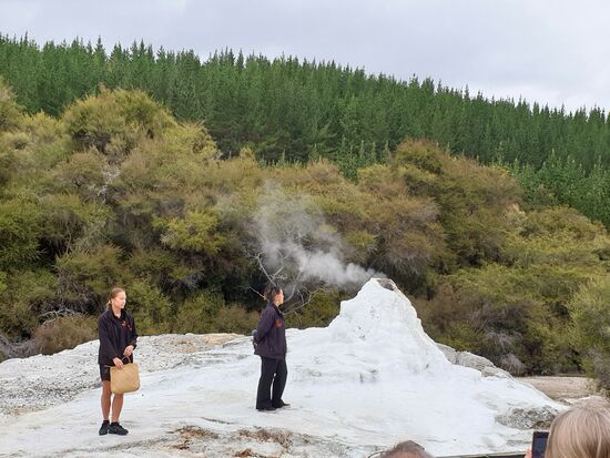 Die rechte Dame erklärt es. Wegen ausgefallenem Mikrofon nur schwer zu verstehen. Die linke Dame kippt den Inhalt der Papiertüte in den Geysier:
Abrakadabra